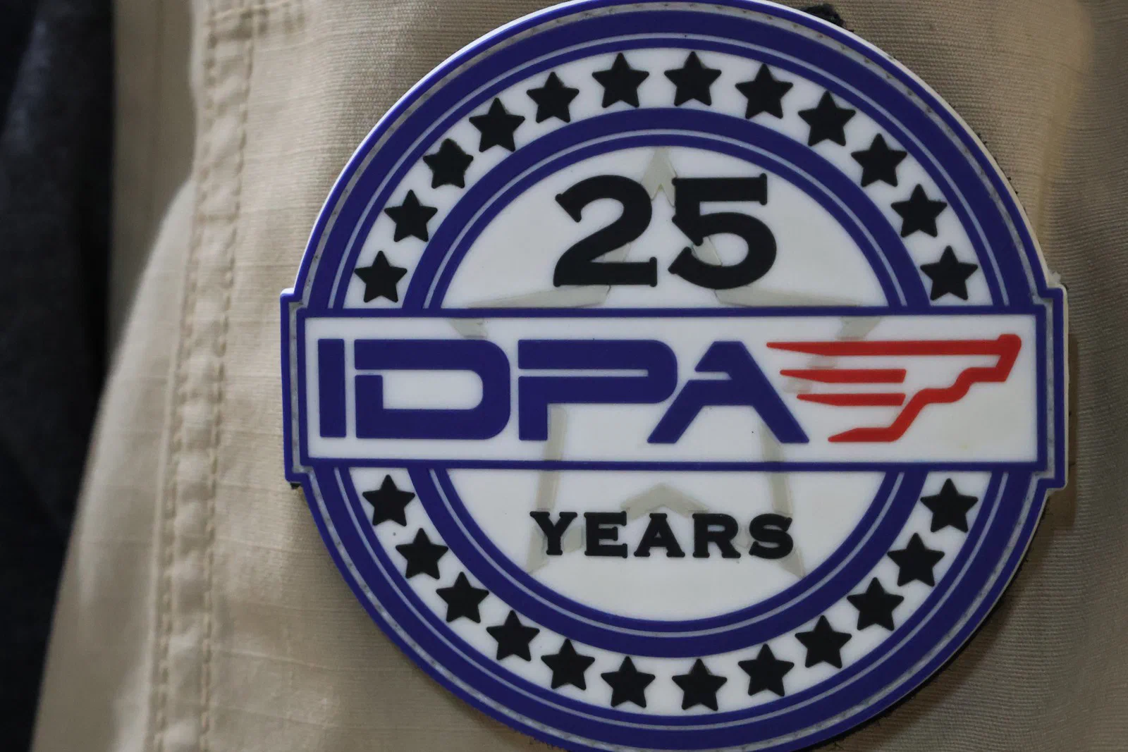 A round IDPA 25 Years commemorative patch on a vest