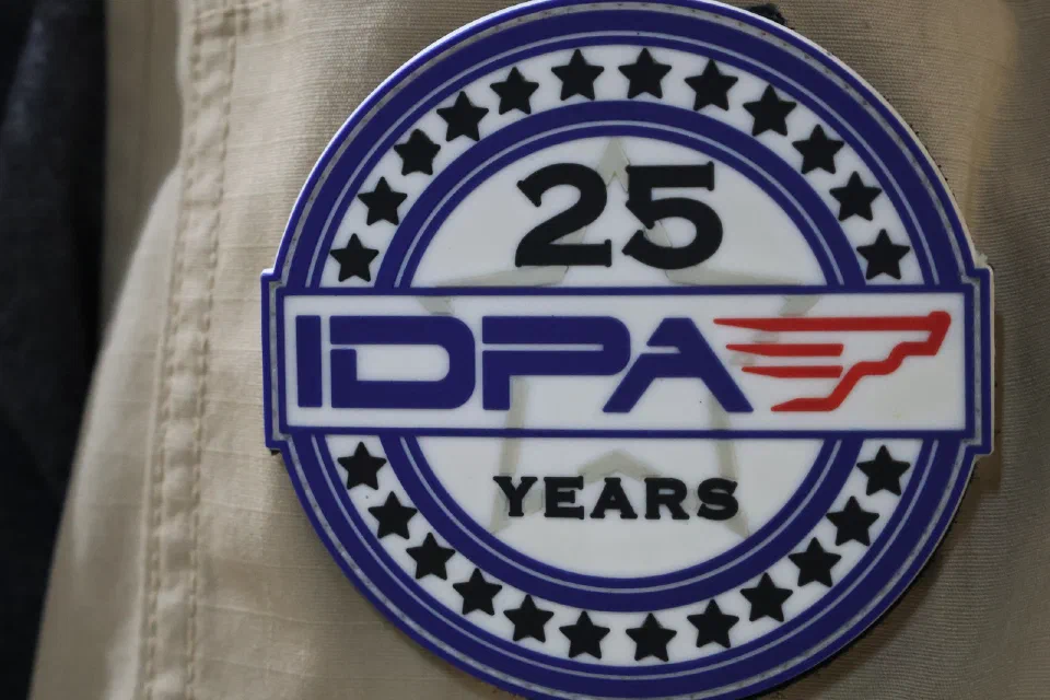 A round IDPA 25 Years commemorative patch on a vest