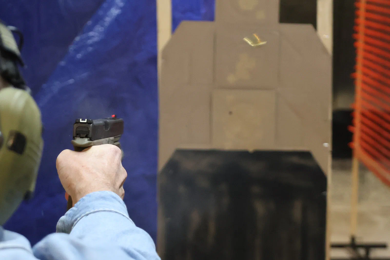 A shooter firing at a target whose lower half is covered by a black panel