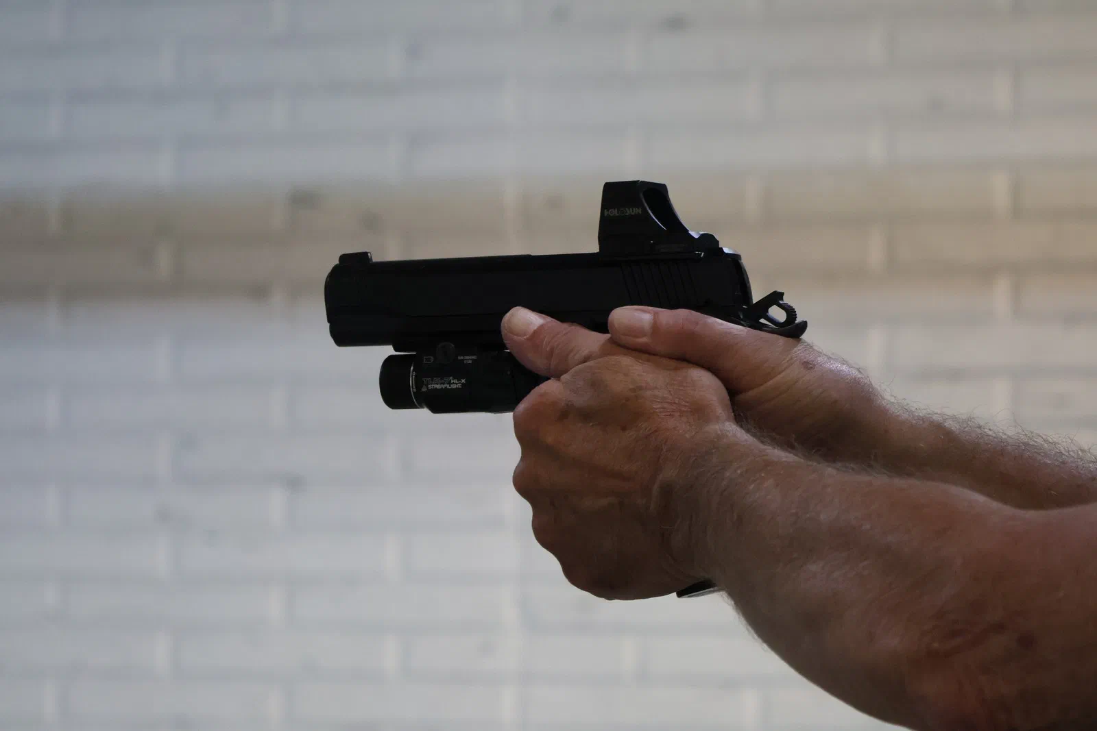 A pistol with a red-dot sight and a weapon-mounted light