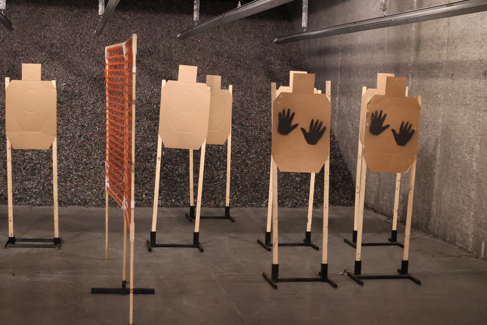 Several cardboard targets on stands, two of them marked with black open hands