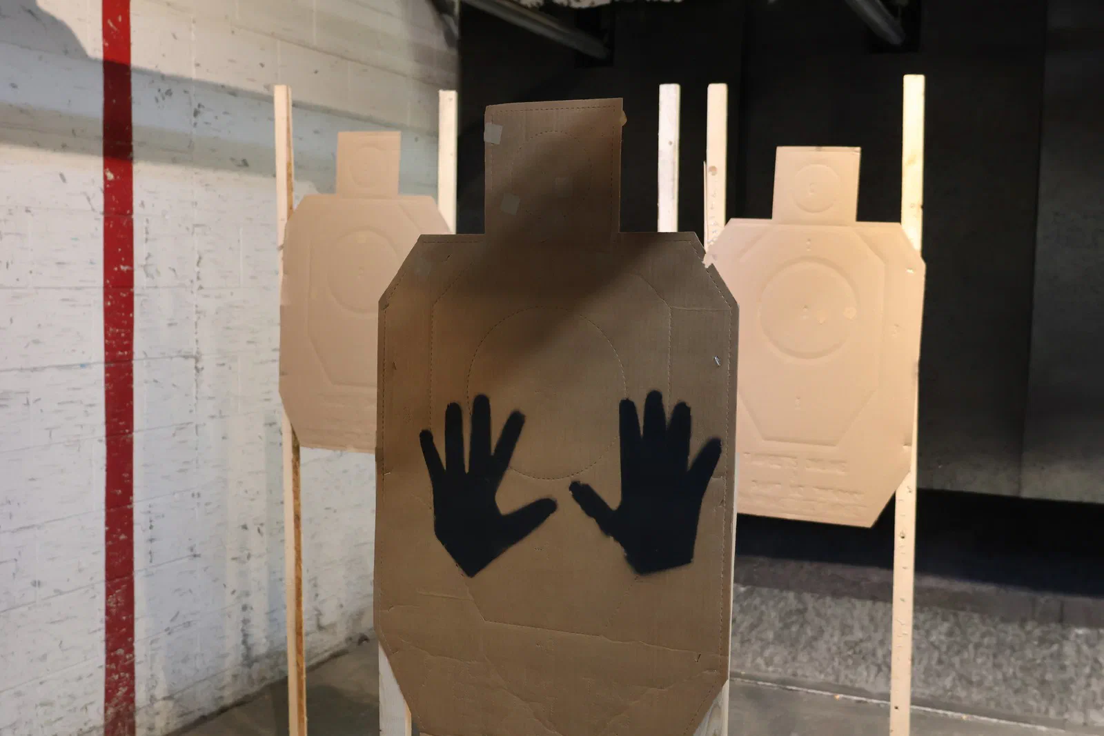 A cardboard target with two black open hands painted on it