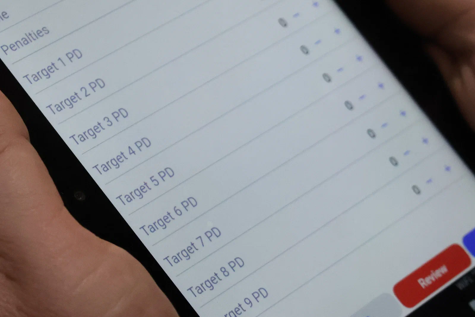 A tablet showing a score sheet with a row for each target